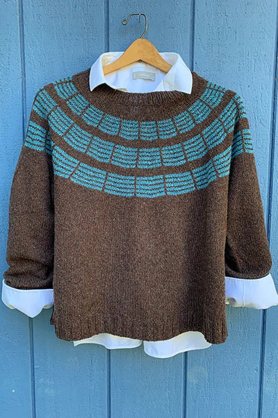 A brown pullover sweater has turquoise stripes around the yoke