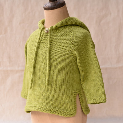 a bright green knitted baby tunic with hood