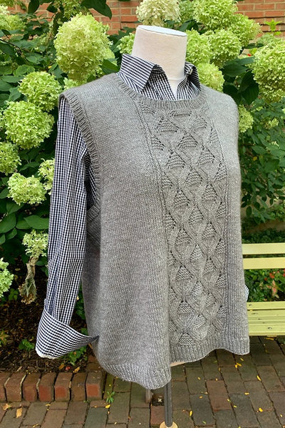 A grey knitted vest with a triangular stitch pattern on the front