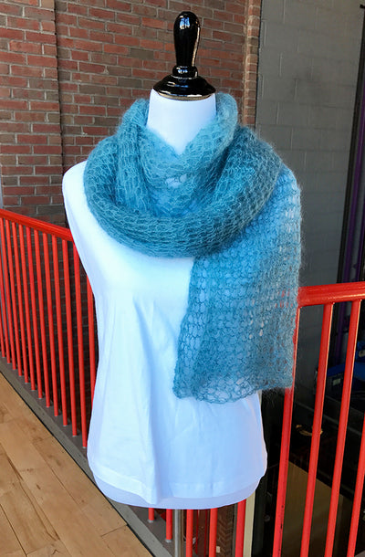 A blue crochet scarf on a mannequin in a white t-shirt