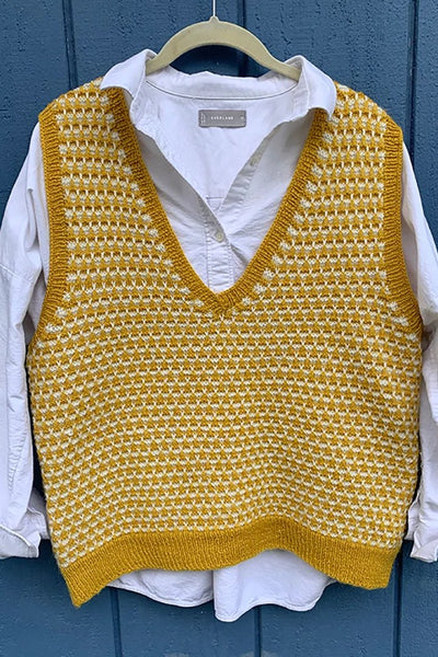 A gold and white patterned knitted vest